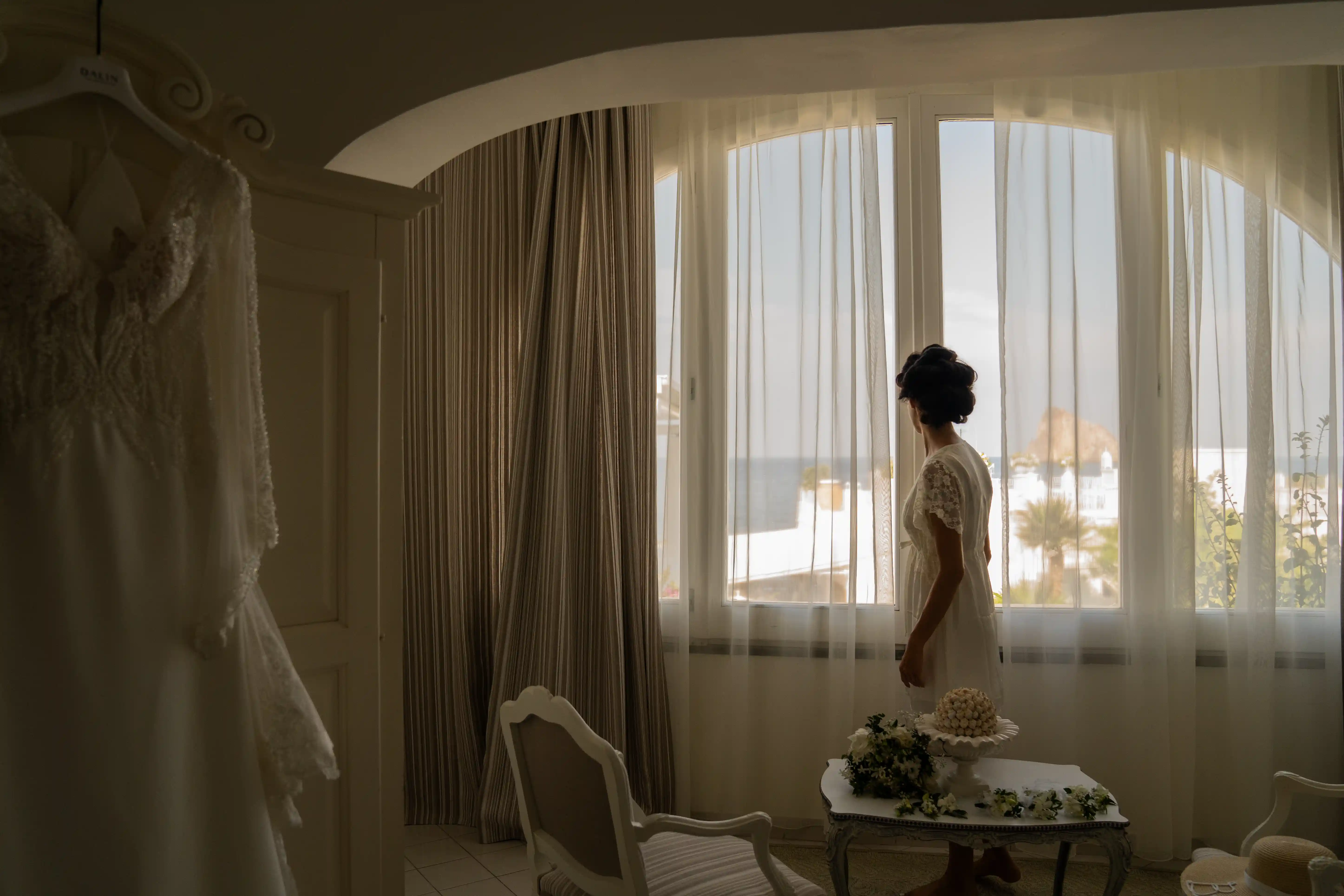 Sposa ai preparativi alla finestra con luce naturale